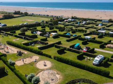 Vue aérienne des emplacements et de la plage du camping bord de mer à Erquy dans les Côtes d'Armor.